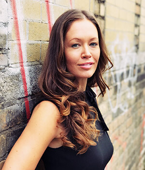 social enterprise entrepreneur Leslie Maleipaard poses against a wall wearing black