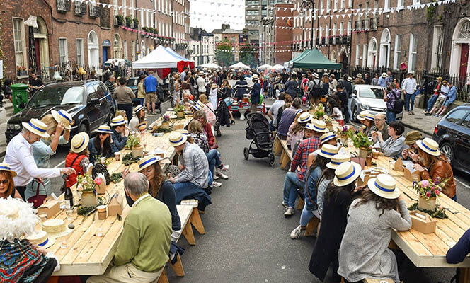 people sitting on benches in street as part of community festival provided by municipal services