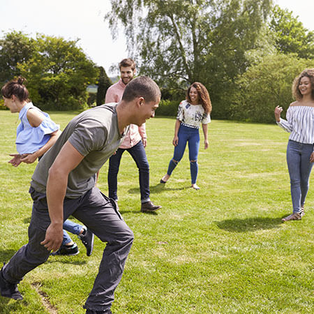 Adult friends having fun with a football on a playing field