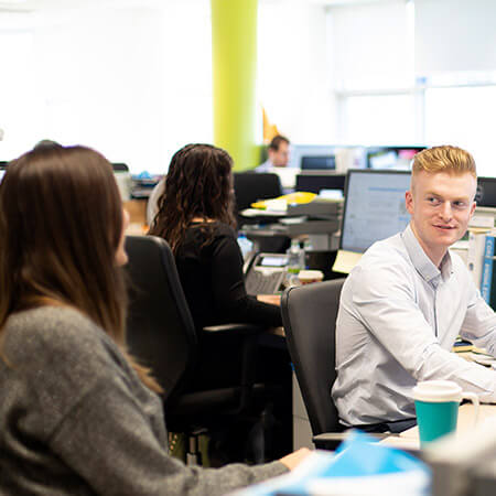 young workforce sitting in office typing on computer