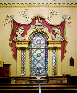 colourful venetian window surrounded by plaster angels