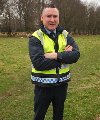 phoenix park deer keeper stands with arms crossed in high vis vest