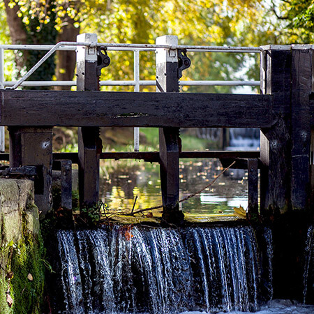 water flowing through a black and white lock on a dublin canal