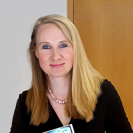 a photo of alison lyons, the director of the Dublin unesco City of Literature programme, holding a copy of echoland