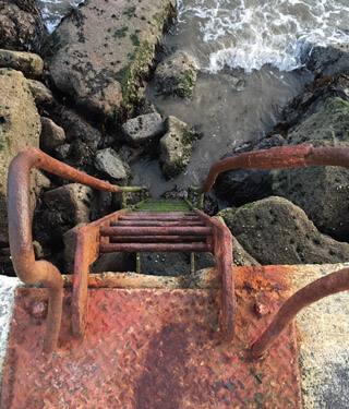 red ladder down to the beach at south wall