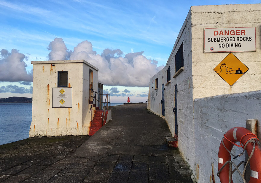 a life preserving ring and warning signs at the half moon swimming club house 