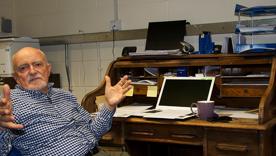 John Scally seated at his desk