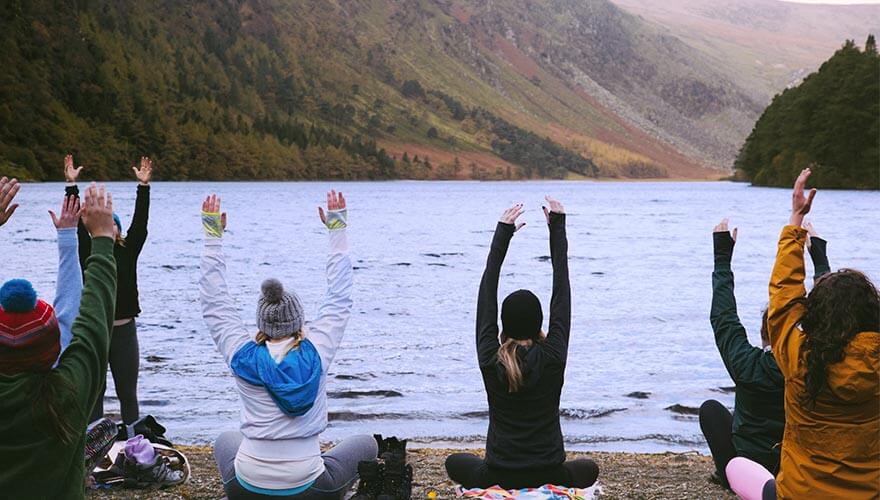 members of galz gone wild doing yoga at wicklow lake edge