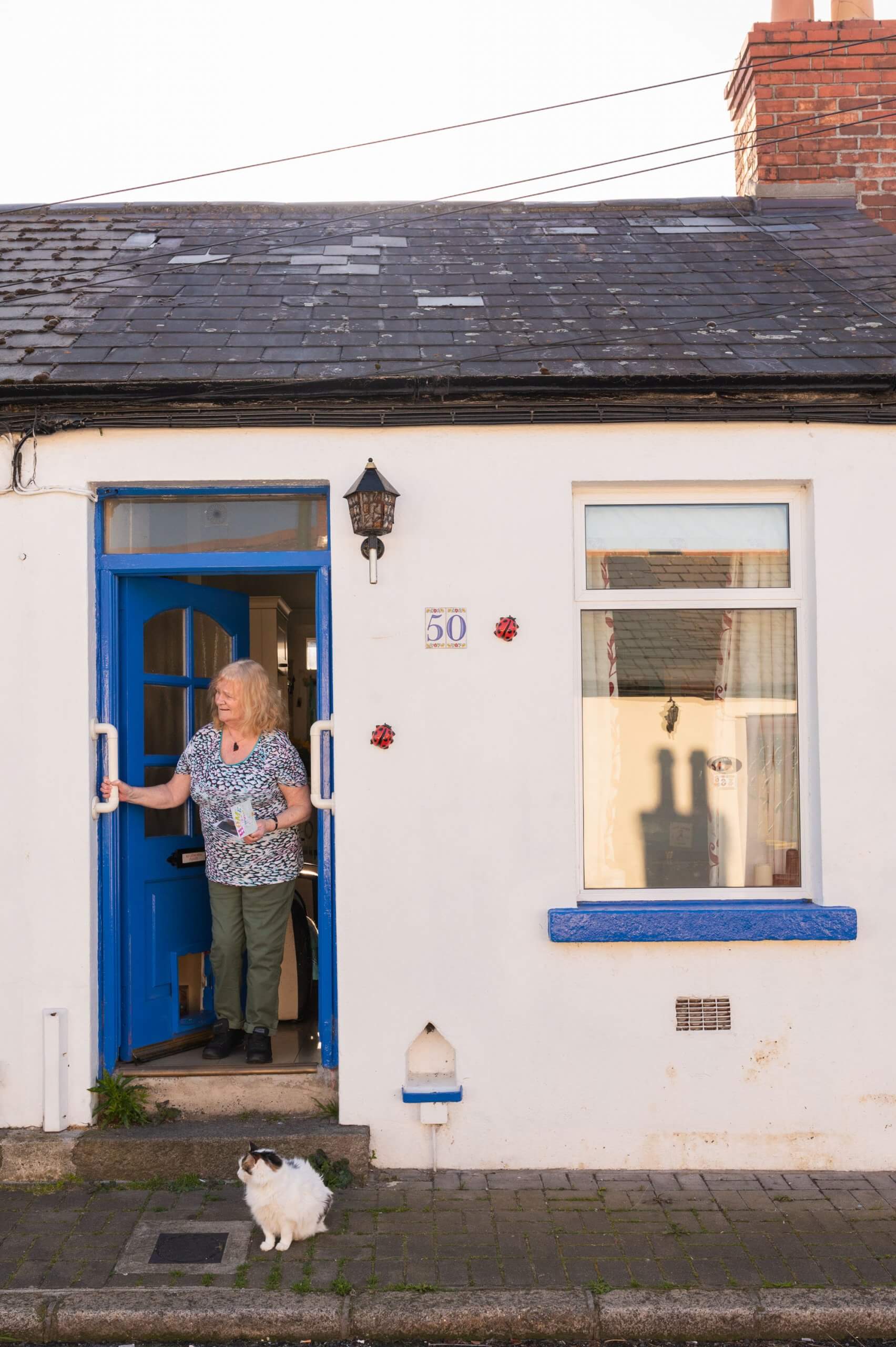 A woman stands in her front door