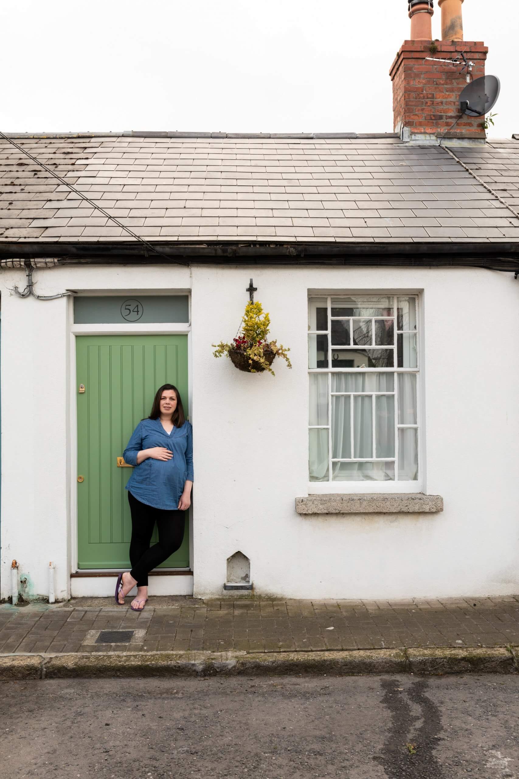 A woman leans against her front door