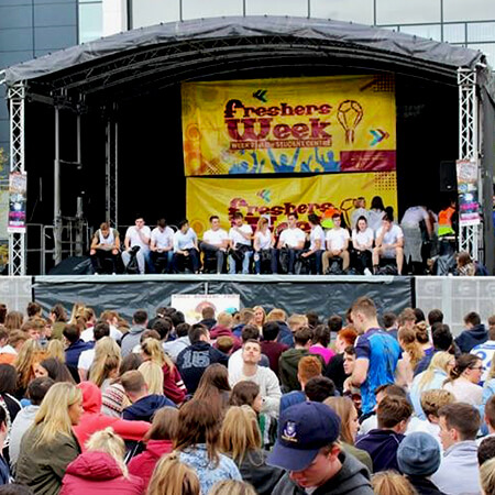 students gather under a fresher's week sign