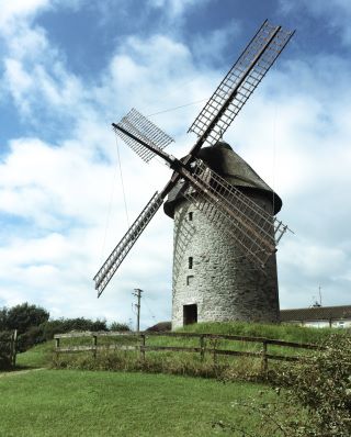 old stone mill set against blue cloudy sky in skerries