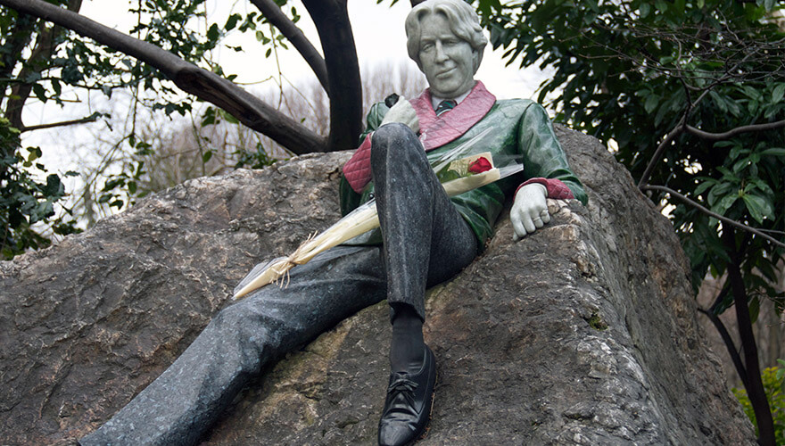 a colourful of oscar wilde sprawled on a rock in merrion square